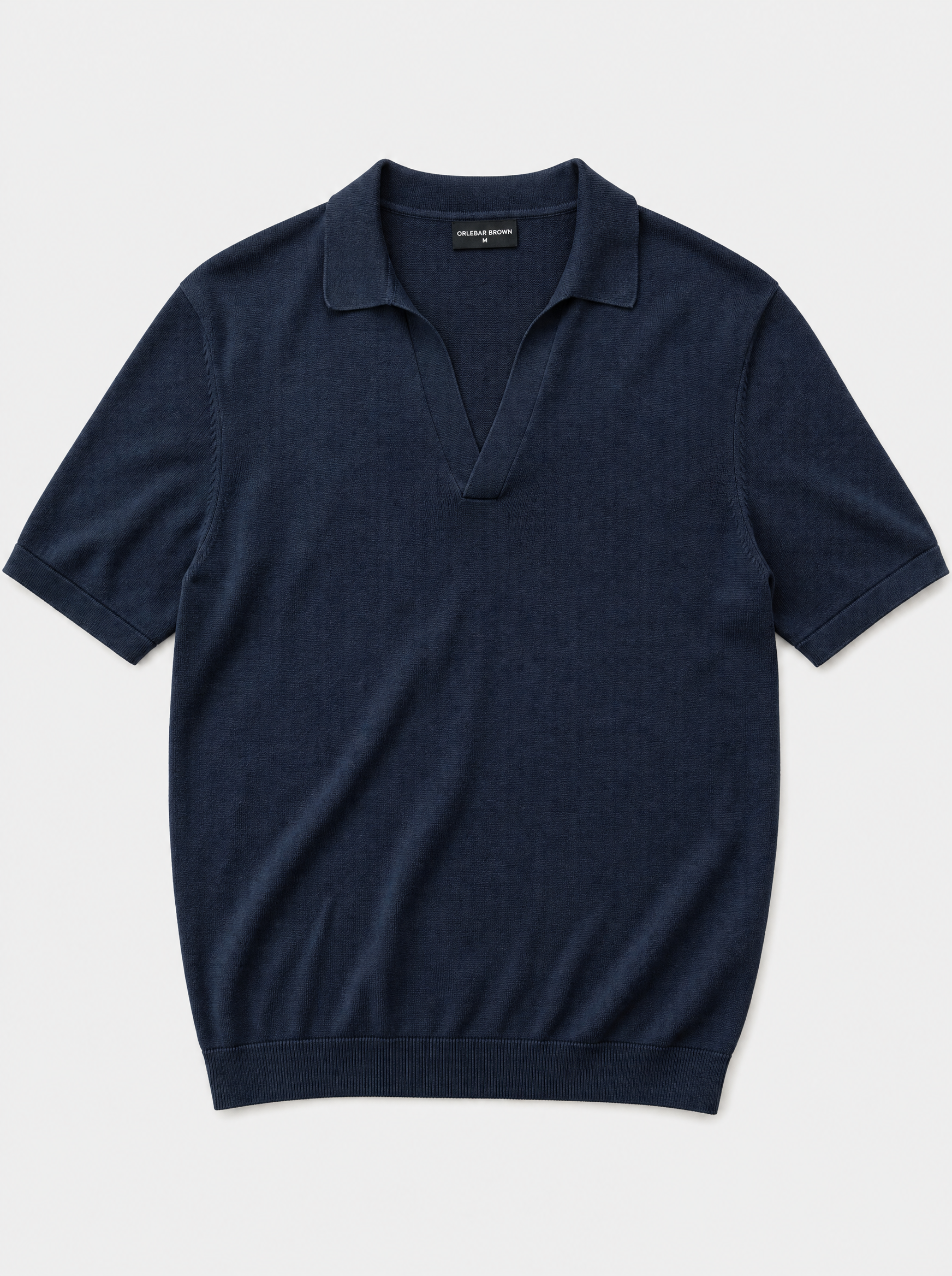 The Portofino Polo — navy fine-gauge knit cotton short-sleeve henley polo, front view